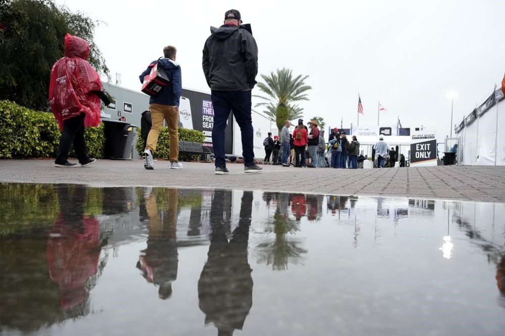 People exit the Fan Zone area after the NASCAR Xfinity auto race was postponed because of rain at Daytona International Speedway, Saturday, Feb. 17, 2024, in Daytona Beach, Fla. (AP Photo/John Raoux)