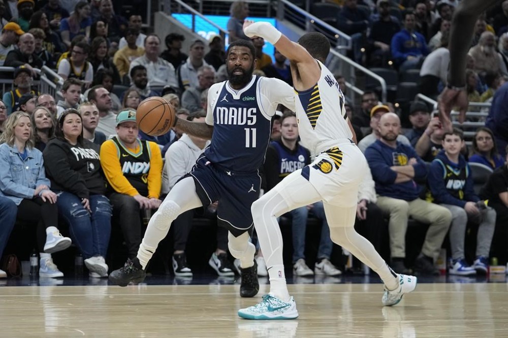 Dallas Mavericks' Kyrie Irving (11) heads to the basket against Indiana Pacers' Tyrese Haliburton, right, during the first half of an NBA basketball game, Sunday, Feb. 25, 2024, in Indianapolis. (AP Photo/Darron Cummings)