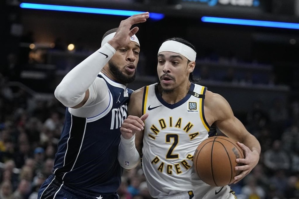 Indiana Pacers' Andrew Nembhard (2) is defended by Dallas Mavericks' Daniel Gafford, left, during the second half of an NBA basketball game, Sunday, Feb. 25, 2024, in Indianapolis. (AP Photo/Darron Cummings)