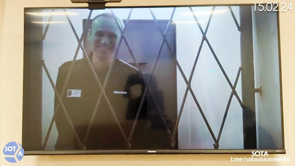 This photo taken from video released by Russian Federal Penitentiary Service via SOTAVISION shows Russian opposition leader Alexei Navalny appears via a video link from the Arctic penal colony in Kharp, in the Yamalo-Nenetsk region about 1,900 kilometers (1,200 miles) northeast of Moscow, where he is serving a 19-year sentence, in Kovrov, Russia, on Feb. 15, 2024. Shortly after Navalny's death was reported on Friday Feb. 16, 2024, the Russian SOTA social media channel shared images of the opposition politician reportedly in court yesterday. In the footage, Navalny is seen standing up and is laughing and joking with the judge via video link. (Russian Federal Penitentiary Service via SOTAVISION via AP)