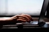 The federal government is introducing legislation designed to help protect young people in Canada from the dangers they face online. A woman types on a laptop on a train in New Jersey on May 18, 2021. THE CANADIAN PRESS/AP, Jenny Kane