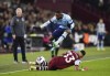 Brentford's Frank Onyeka jumps over West Ham United's Emerson Palmieri during the English Premier League soccer match between West Ham United and Brentford at the London Stadium, London, Monday Feb. 26, 2024. (Zac Goodwin/PA via AP)