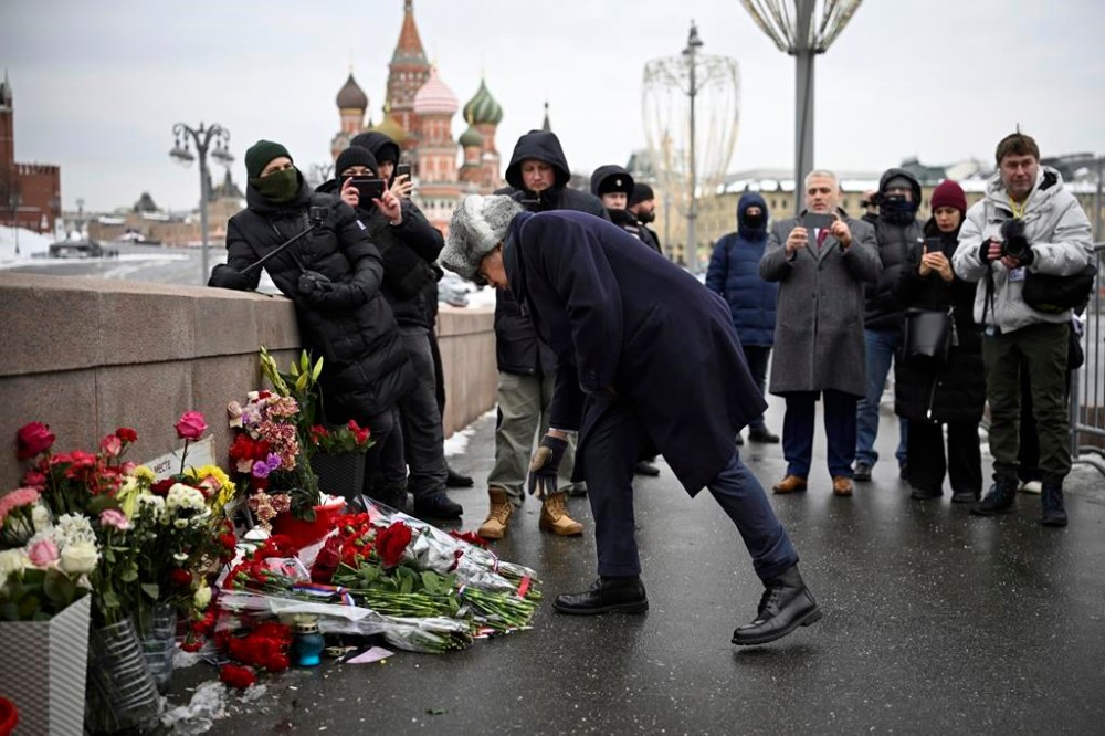 French Ambassador to Russia Pierre L'vy lays flowers at the place where Russian opposition leader Boris Nemtsov was gunned in 2015, as he comes to mark the 9th anniversary of his killing in Moscow, with the Kremlin in the background, Russia, Tuesday, Feb. 27, 2024. (AP Photo)