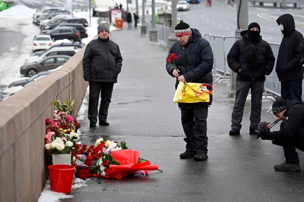 A man lays flowers at the place where Russian opposition leader Boris Nemtsov was gunned in 2015, as he comes to mark the 9th anniversary of his killing in Moscow, Russia, Tuesday, Feb. 27, 2024. (AP Photo)
