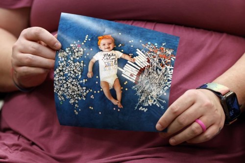 Elizabeth Goldman holds a photo of her daughter, Zari Grace, as she tells her story to Secretary of U.S. Health and Human Services Xavier Becerra who hosted a panel discussion with families directly affected by the Alabama Supreme Court Court decision, Tuesday, Feb. 27, 2024, in Birmingham, Ala. (AP Photo/Butch Dill)