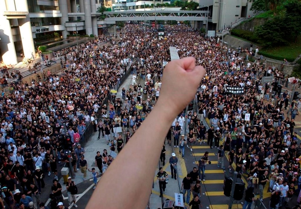 FILE - Tens of thousands of people march through a Hong Kong street Tuesday, July 1, 2003, to protest the Hong Kong government's plans to enact an anti-subversion bill that critics feared would curtail civil liberties. The bill was withdrawn after the march. Hong Kong’s plan to enact a new national security law, on top of a sweeping legislation that was imposed by Beijing and used to crack down on dissent, is deepening concerns over the erosion of freedoms in the former British colony.(AP Photo/Vincent Yu, File)