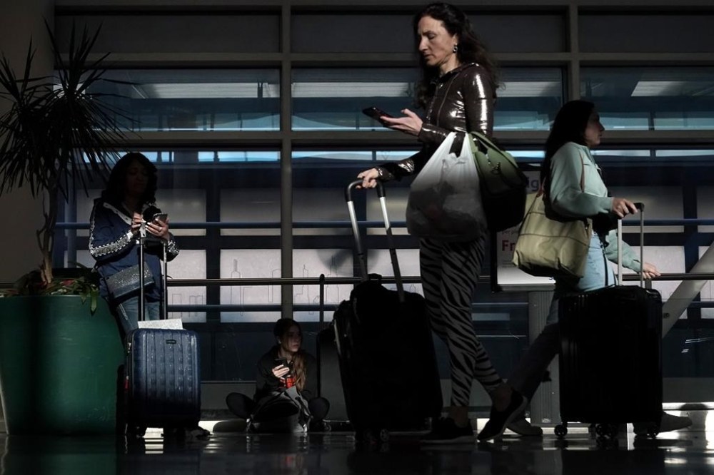FILE - Commercial airline passengers wait, and make their way through the ticketing level at Chicago's Midway International Airport Friday, May 26, 2023, in Chicago. U.S. airfares are, on average, 15% lower now than they were a decade ago, and 6% lower than this time last year. The same cannot be said for many other purchasing categories where prices are increasing due to inflation. (AP Photo/Charles Rex Arbogast, File)