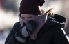 A person tries to stay warm as they walk in downtown Ottawa, Friday, February 3, 2023. Environment Canada is warning a sharp cold front passing through Ontario Wednesday afternooon will dramatically shift weather conditions in most parts of the province.THE CANADIAN PRESS/Adrian Wyld