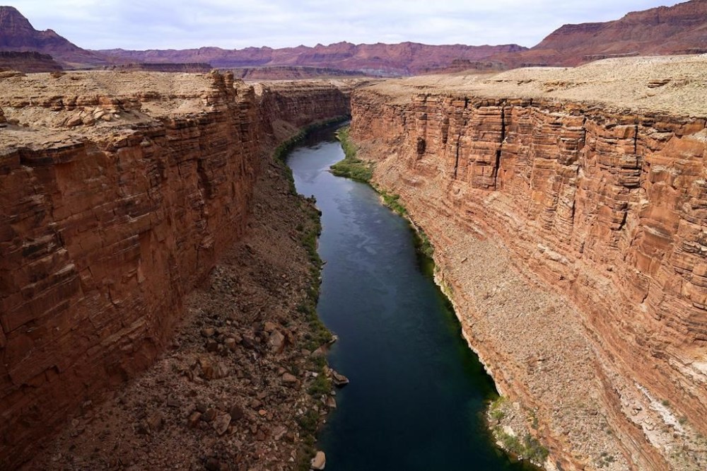 FILE - The Colorado River in the upper River Basin is seen, May 29, 2021, in Lees Ferry, Ariz. The Navajo Nation, a Native American tribe with one of the largest outstanding claims to water in the Colorado River basin, is closing in on a settlement with more than a dozen parties, putting it on a path to piping water to tens of thousands of tribal members in Arizona who still live without it. Negotiating terms outlined Wednesday, Feb. 28, 2024, include water rights not only for the Navajo Nation but the neighboring Hopi and San Juan Southern Paiute tribes in the northeastern corner of the state. (AP Photo/Ross D. Franklin, File)