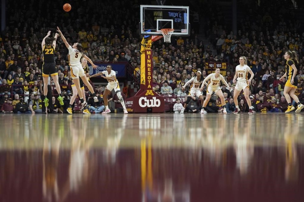 Iowa guard Caitlin Clark (22) shoots over Minnesota guard Maggie Czinano (5) during the first half of an NCAA college basketball game Wednesday, Feb. 28, 2024, in Minneapolis. (AP Photo/Abbie Parr)