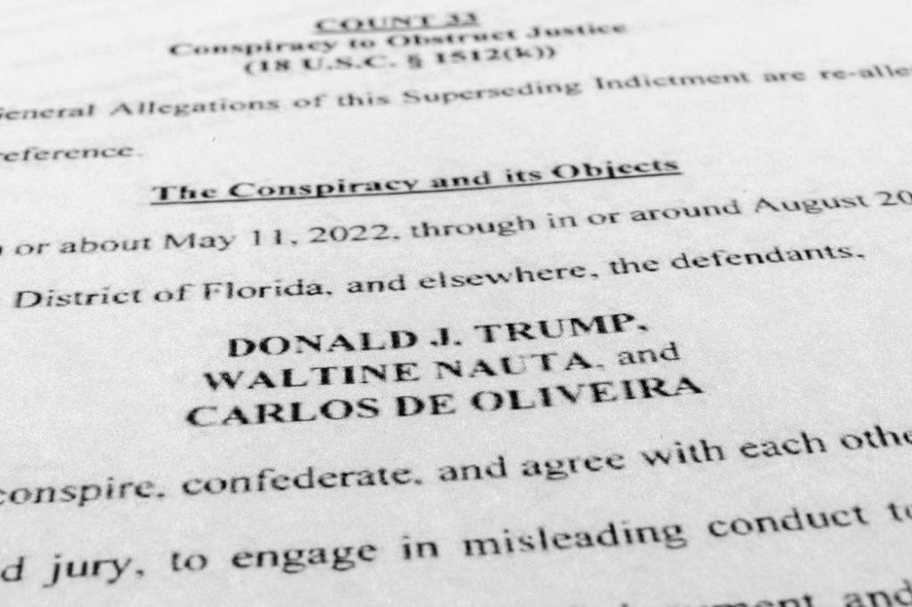 FILE - The updated indictment against former President Donald Trump, Walt Nauta and Carlos De Oliveira is photographed July 27, 2023. The federal judge overseeing the classified documents prosecution of Trump is expected to set a trial date during a court hearing on March 1, 2024. (AP Photo/Jon Elswick, File)