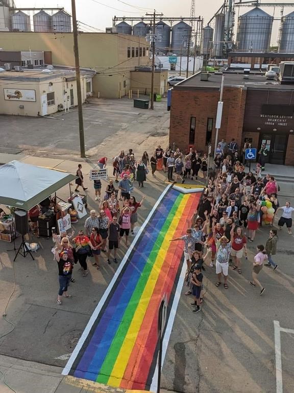 Students and adults stand beside a Pride crosswalk they painted in Westlock, Alta., in a May, 2023 handout photo. The crosswalk is to be removed after residents voted in February to have only government flags and white-striped crosswalks on municipal property. THE CANADIAN PRESS/HO-Nicky Vranas **MANDATORY CREDIT**