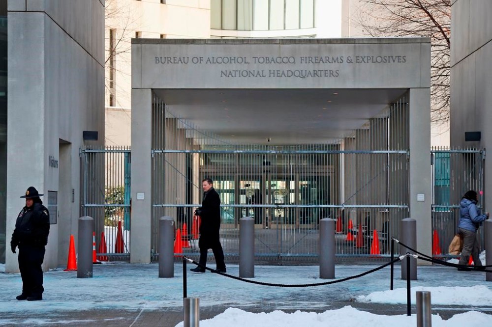 FILE - In this Thursday, Jan. 23, 2014 photo, a security official walks in front of the entrance to the national headquarters of the Bureau of Alcohol, Tobacco, Firearms and Explosives in Washington. On Friday, March 1, 2024, The Associated Press reported on stories circulating online incorrectly claiming an update to the Bureau of Alcohol, Tobacco, Firearms and Explosives’ background check policy allows people in the U.S. illegally to purchase firearms. (AP Photo/Charles Dharapak, File)