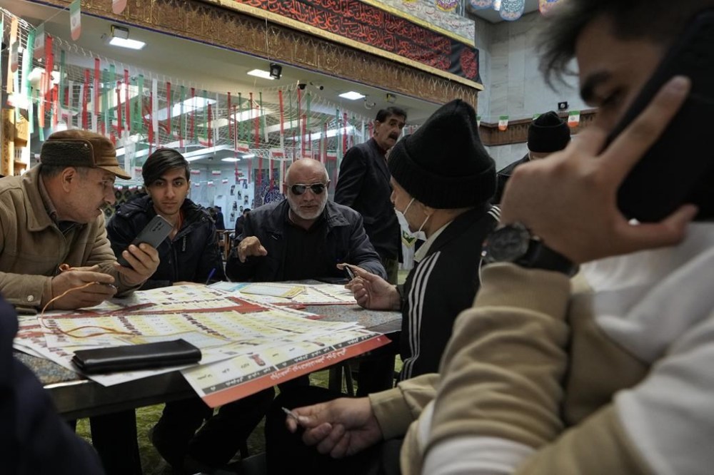 Voters fill out their ballots during the parliamentary and Assembly of Experts elections at a polling station in Tehran, Iran, Friday, March 1, 2024. Iran on Friday held the country's first election since the mass 2022 protests over mandatory hijab laws after the death in police custody of Mahsa Amini, with questions looming over just how many people will turn out at the polls. (AP Photo/Vahid Salemi)
