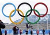 FILE - A participant hangs from the Olympic rings while posing for a teammate at Olympic Park ahead of the 2014 Winter Olympics, Wednesday, Feb. 5, 2014, in Sochi, Russia. A commission charged with reviewing the Olympic system in the United States recommended in a report Friday, March 1, 2024, that Congress rework key facets of the U.S. Center for SafeSport, including making it completely independent of the U.S. Olympic and Paralympic Committee and reimagining the way it deals with cases in the grassroots. (AP Photo/Robert F. Bukaty, File)