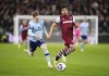 Brentford's Keane Lewis-Potter and West Ham United's Lucas Paqueta, right, battle for the ball during the English Premier League soccer match between West Ham United and Brentford at the London Stadium, London, Monday Feb. 26, 2024. (Zac Goodwin/PA via AP)