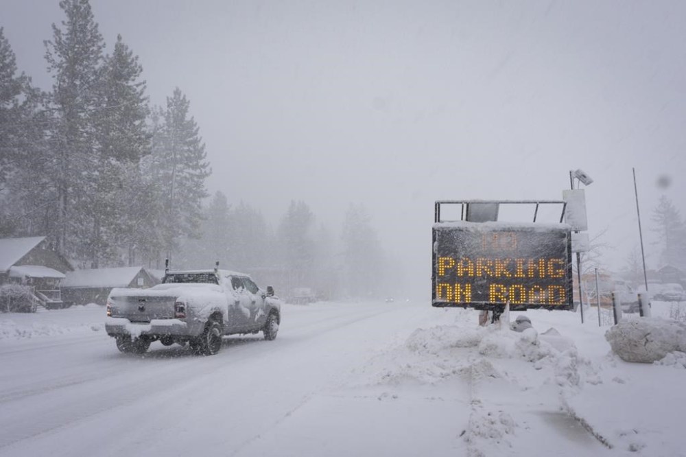 A sign warms motorists of parking restrictions as snow falls Friday, March 1, 2024, in Truckee, Calif. (AP Photo/Brooke Hess-Homeier)