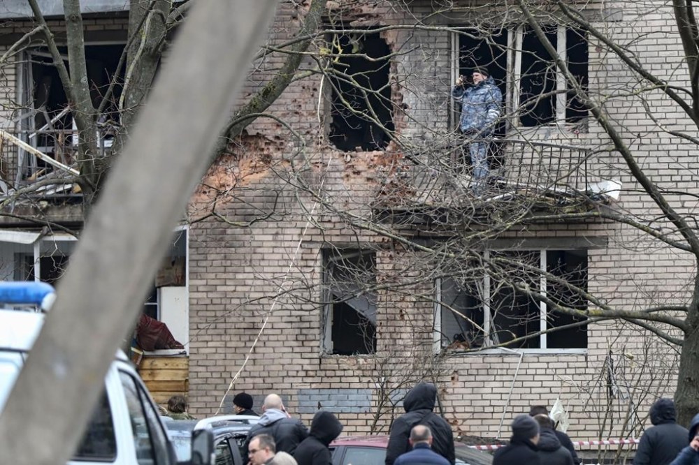 An investigator works at the side of the damaged apartment's building after a reported drone attack in St. Petersburg, Russia, Saturday, March 2, 2024. Russian authorities said Saturday morning that an