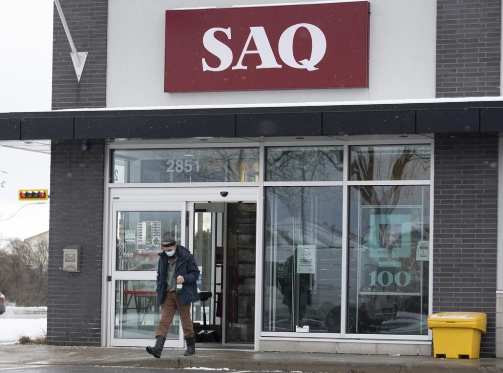 A customer leaves an SAQ outlet Thursday, January 6, 2022 in Deux-Montagnes, Quebec. Members of a union representing more than 5,000 Quebec liquor store employees have voted in favour of a strike amid stalled negotiations that union leadership says have dragged on for a year. THE CANADIAN PRESS/Ryan Remiorz