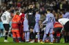 Valencia's goalkeeper Giorgi Mamardashvili, center, reacts after Valencia's Mouctar Diakhaby receives treatment after getting an injury during the La Liga soccer match between Valencia and Real Madrid at the Mestalla Stadium in Valencia, Spain, Saturday, March 2, 2024. (AP Photo/Jose Breton)