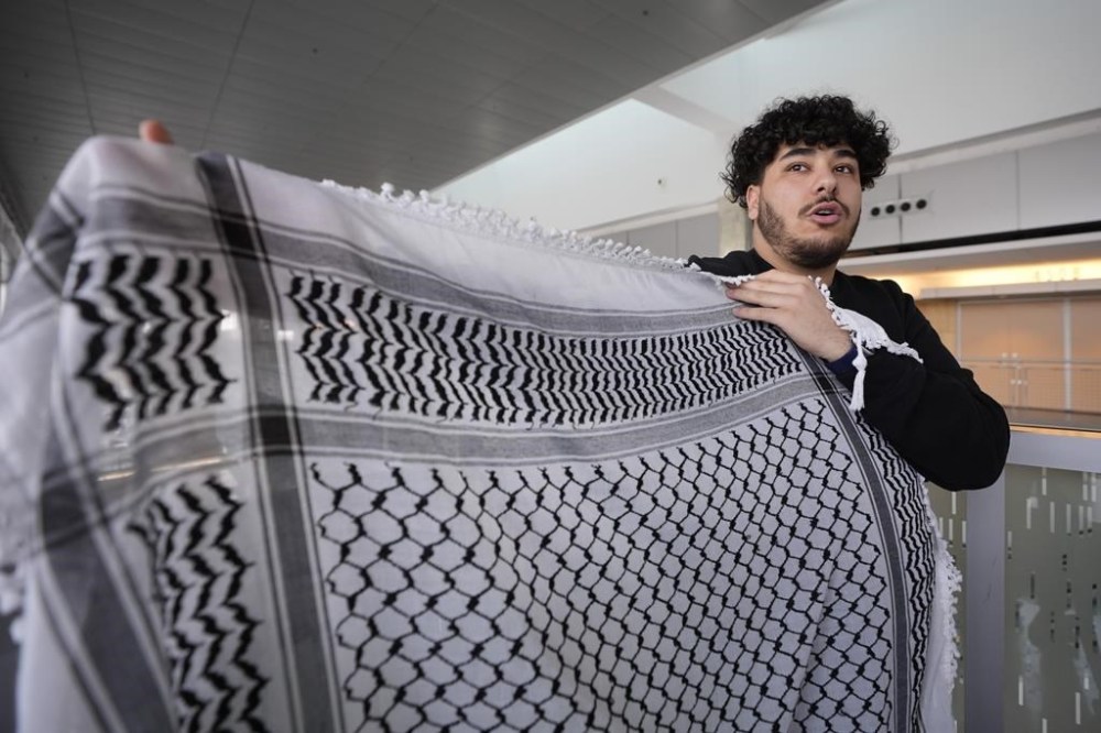 Yaqoub Saadeh holds a keffiyeh as he speaks about an Indiana bill to address antisemitism on college campuses, Wednesday, Feb. 7, 2024, in Indianapolis. The heart of most opposition leveled against the bill from pro-Palestinian and anti-Israel voices. State senators passed the amended version of the bill Tuesday in a 42-6 vote. But it needs final approval from the House, where the bill originated, before becoming law. (AP Photo/Darron Cummings)