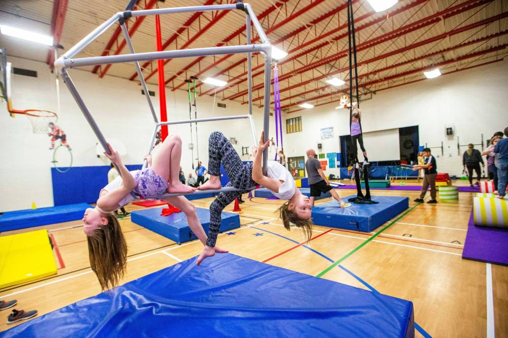Grade four students Ashlynn Miller (left) and Ellie Betts, as well as other students from Heritage and Robert Browning Schools, demonstrate the aerial cube. (Mikaela MacKenzie / Winnipeg Free Press)
