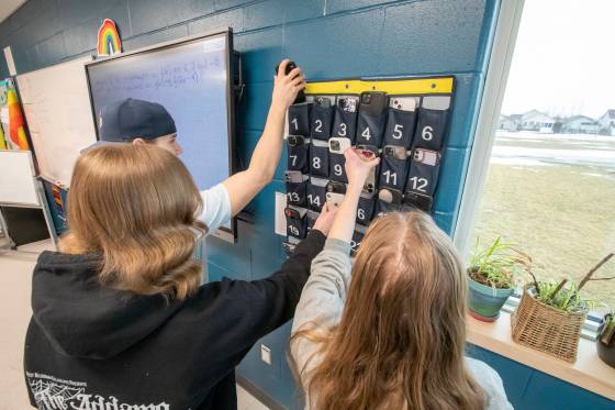 Grade 12 students put their cell phones in a storage pouch before their pre-calculus class at West Kildonan Collegiate Thursday. (Brook Jones / Winnipeg Free Press)