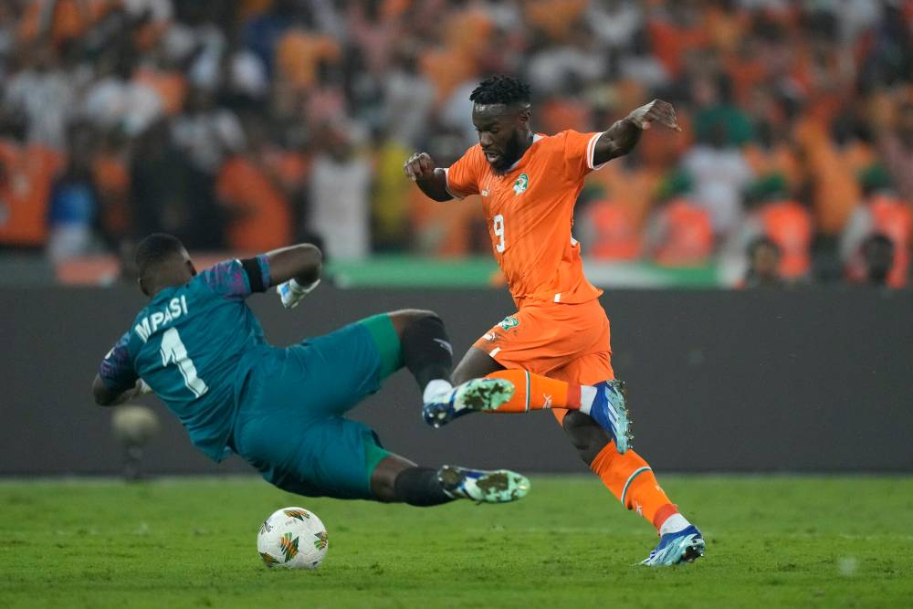 SUNDAY ALAMBA / THE ASSOCIATED PRESS
Ivory Coast’s Jonathan Bamba scampers around DR Congo goalkeeper Lionel Mpasi during an African Cup of Nations semifinal match on Wednesday.