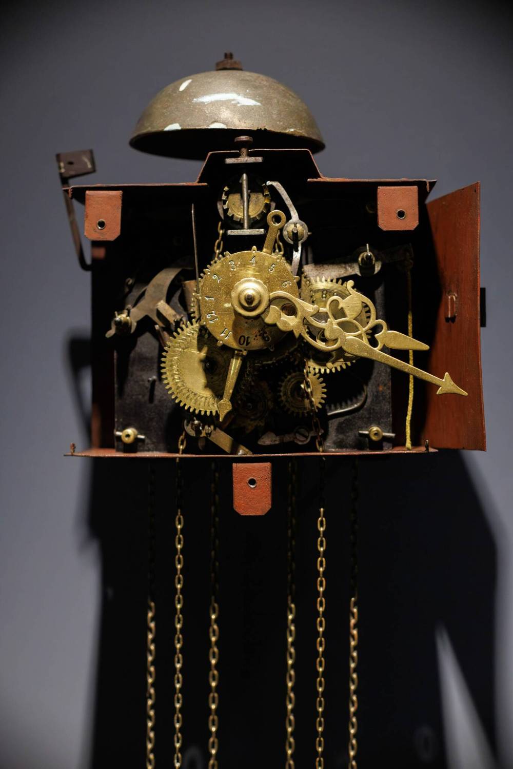 MIKE DEAL / WINNIPEG FREE PRESS
This “Cadillac Clock” has all the bells and whistles! It demonstrates the highest sophistication of Mennonite wall clocks, telling the hour, minute, month, and day, and also features an alarm setting (gears and mechanisms, above and below). In contrast to the rope-driven clock, this one has a chain drive. Rope drives required frequent cleaning, as the fibres clogged the mechanism. Chain drives were more expensive but practical.