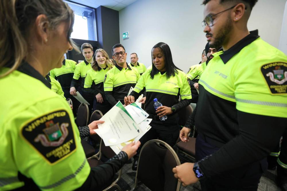 RUTH BONNEVILLE / FREE PRESS
Newly graduated transit safety officers celebrate after receiving their certificates at a graduation ceremony Friday.