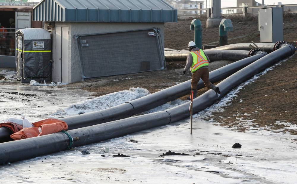 City crews work to bypass a sewage leak across the Red River at the Fort Garry Bridge in Tuesday. (JOHN WOODS / FREE PRESS FILES)