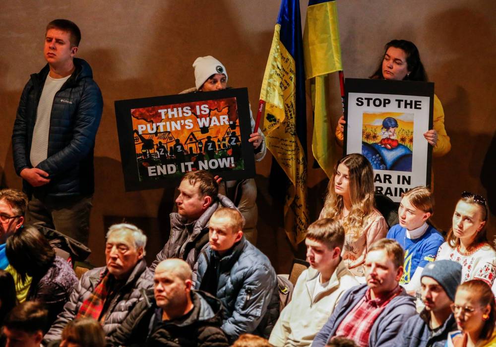 Many attendees carried Ukrainian flags and signs, with some shedding tears as they listened to impassioned speeches from community leaders and Manitoba politicians. (John Woods / Free Press)