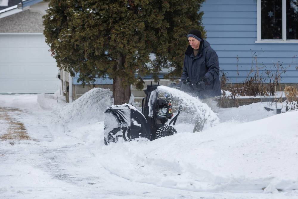 Lawrence Gargo clears the sidewalk on his street in Fort Rouge on Monday morning. (Mike Deal / Free Press)
