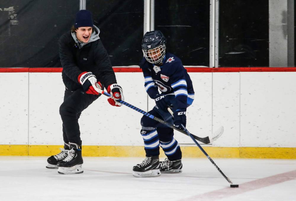 JOHN WOODS / FREE PRESS
                                Winnipeg Jets’ Morgan Barron (left) coaches Canari Yonas, who plays defence, through a drill.