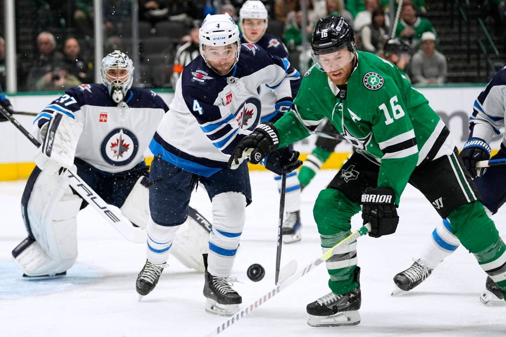 Winnipeg Jets defenceman Neal Pionk and Dallas Stars centre Joe Pavelski chase the puck during the first period. (AP Photo/Tony Gutierrez)
