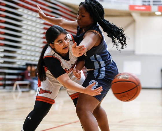 University of Winnipeg Collegiate Wesmen’s Umme Mani Ali (left) passes around Gray Academy Raiders’ Osikhe Lamai in Zone 12, Tier 1 AAA varsity girls high school basketball action Monday at the University of Winnipeg. (John Woods / Winnipeg Free Press)