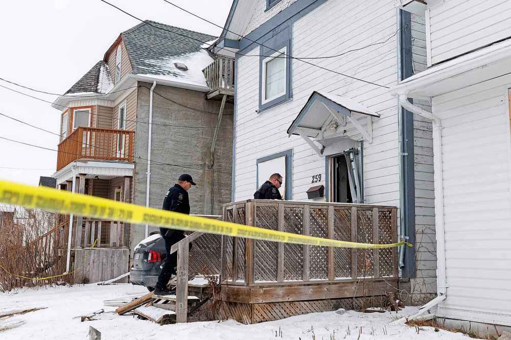 On Wednesday, Winnipeg police forensics investigators were seen working at the two-and-a-half-storey home, coming and going from the broken front door. (Mike Deal / Winnipeg Free Press)
