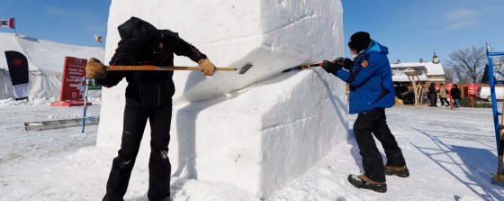 Franziska Agrawal (left) from Munich, Germany and Bob Fulks (right) from Detroit, USA, team up to work on an snow sculpture they have titled Twist. (Mike Deal / Free Press)