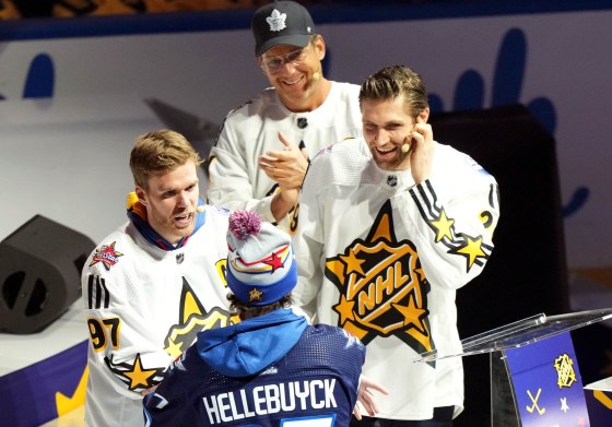 Connor McDavid (left) of Team McDavid welcomes Connor Hellebuyck as the team's first pick as Leon Draisaitl (right) and Will Arnett look on during the NHL All-Star week draft in Toronto on Thursday. (Nathan Denette / The Canadian Press)