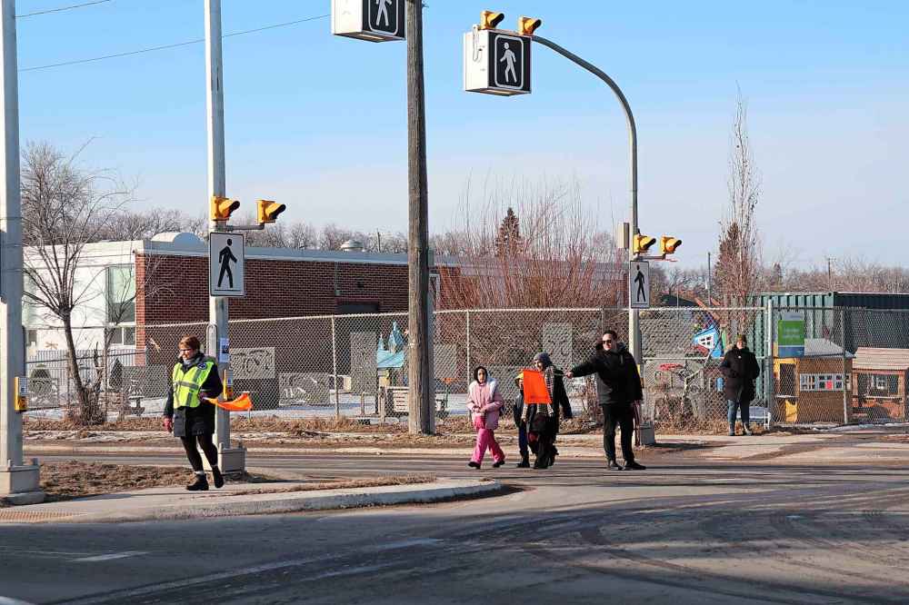 Pedestrians cross the street later in the day. (Tyler Searle / Winnipeg Free Press)