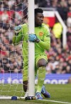 Manchester United's goalkeeper Andre Onana holds the goalpost after making a save during an English Premier League soccer match between Manchester United and Everton at the Old Trafford stadium in Manchester, England, Saturday, March 9, 2024. (AP Photo/Dave Thompson)