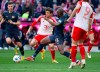 Munich's Thomas M'ller, left, and Mainz's Josuha Guilavogui fight for the ball during the German Bundesliga soccer match between Bayern Munich and Mainz, at the Allianz Arena stadium, in Munich, Germany, Saturday, March 9, 2024. Guilavogui has thanked referee Patrick Ittrich on Sunday for potentially saving his life in a Bundesliga game after his tongue blocked his airway. (Sven Hoppe/dpa via AP)