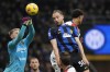Genoa's goalkeeper Josep Martinez stop the ball by the Inter Milan's Carlos Augusto, right, during a Serie A soccer match between Inter Milan and Genoa at the San Siro stadium in Milan, Italy, Monday, March 4, 2024. (AP Photo/Luca Bruno)