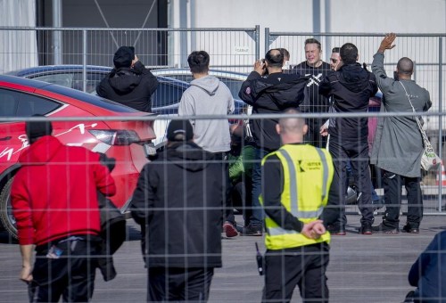 Tesla CEO Elon Musk, 4th from right, arrives at the Tesla Gigafactory for electric cars in Gruenheide near Berlin, Germany, Wednesday, March 13, 2024. Power has been restored to electric car manufacturer Tesla's factory near Berlin about a week after an outage believed to have been caused by arson, a network operator says. (AP Photo/Ebrahim Noroozi)