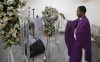 A priest swings incense in front of a photo of police officer Luciana Pierre during her memorial in Port-au-Prince, Haiti, Tuesday, March 12, 2024. According to the family, Pierre was killed in an attack by armed gangs the previous week and her body has not been recovered. (AP Photo/Odelyn Joseph)