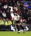 Bournemouth's Chris Mepham, background and Luton Town's Chiedozie Ogbene vie for the ball, during the English Premier League soccer match between Bournemouth and Luton Town, at the Vitality Stadium, in Bournemouth, England, Wednesday, March 13, 2024. (John Walton/PA via AP)