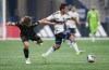 Los Angeles FC's Nathan Ordaz, left, grabs the jersey of Vancouver Whitecaps' Andres Cubas as they vie for the ball during the second half in game 2 of a first-round MLS playoff soccer match, in Vancouver, on Sunday, Nov. 5, 2023. The Whitecaps will renew acquaintances with Los Angeles FC, which ended their playoff run last season, in the Leagues Cup this season. THE CANADIAN PRESS/Darryl Dyck
