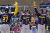 Milwaukee Brewers' Willy Adames (27) celebrates with Christian Yelich (22) and Rhys Hoskins (12) after his two-run home run against the Arizona Diamondbacks during the first inning of a spring training baseball game Sunday, March 3, 2024, in Scottsdale, Ariz. (AP Photo/Ross D. Franklin)