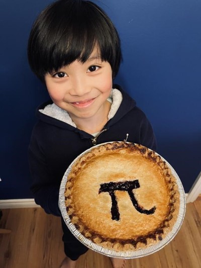Lucas Mason Yao from Pitt Meadows, B.C., holds a pie with a Pi sign on it in a 2023 handout photo. Yao has memorized the ratio between a circle's circumference and its diameter to 2,030 digits, far beyond the three-point-one-four that's close enough for most people. THE CANADIAN PRESS/HO-Cindy Liu