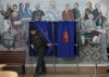 A man leaves a voting booth at a polling station located in a school during the presidential elections in St. Petersburg, Russia, Saturday, March 16, 2024, with a painting depicting the Russian Tsarina Catherine II and her contemporaries on the wall. Voters in Russia are heading to the polls for a presidential election that is all but certain to extend President Vladimir Putin's rule after he clamped down on dissent. (AP Photo/Dmitri Lovetsky)